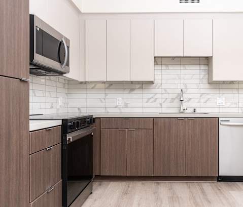 A kitchen with brown cabinets and a white dishwasher.