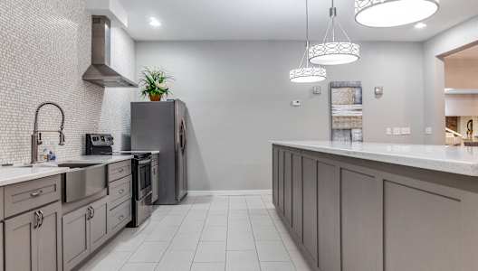 A modern kitchen with a grey color scheme and a large island.