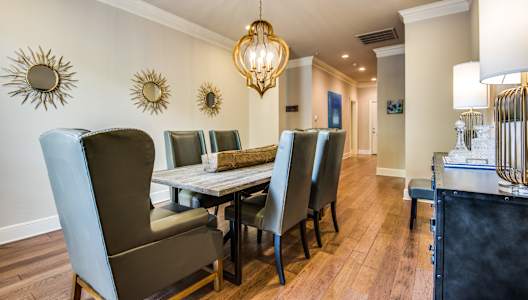 A dining room with a table and chairs.