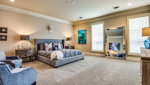 A bedroom with a large bed and a couch.