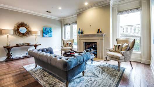 A living room with a blue couch and a fireplace.