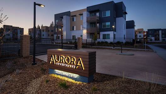 The Aurora Apartments sign at dusk