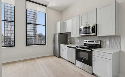 A kitchen with white appliances and cabinets. at LiveWell Apartments, Pittsburgh, PA, 15222