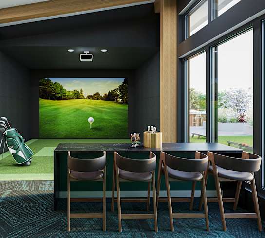 a golf simulator in a room with a table and chairs