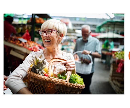 an elderly woman holding a basket of fruit and vegetables at Bigelow Commons, Enfield, Connecticut