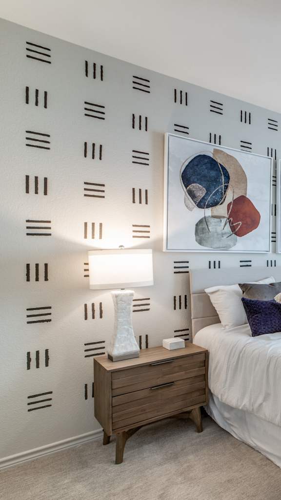 A bedroom with a bed, nightstand, and a ceiling fan.