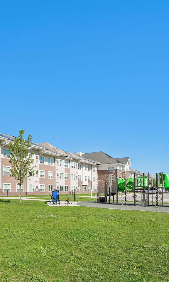 A large apartment complex with a playground in front.