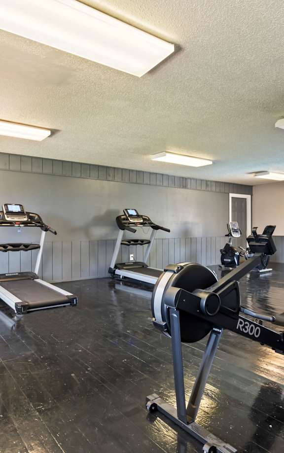 a gym with exercise equipment and a door to a patio