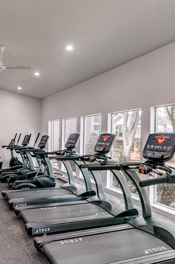 a gym with weights and cardio machines in it