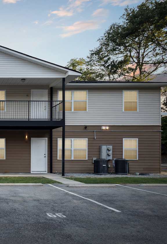 A two-story apartment building with a parking lot in front.