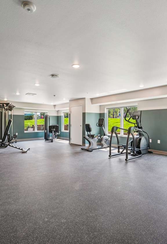 A spacious gym with treadmills, elliptical machines, and other exercise equipment.