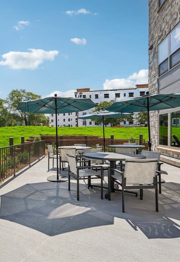 A patio with a table and chairs is surrounded by a metal fence.