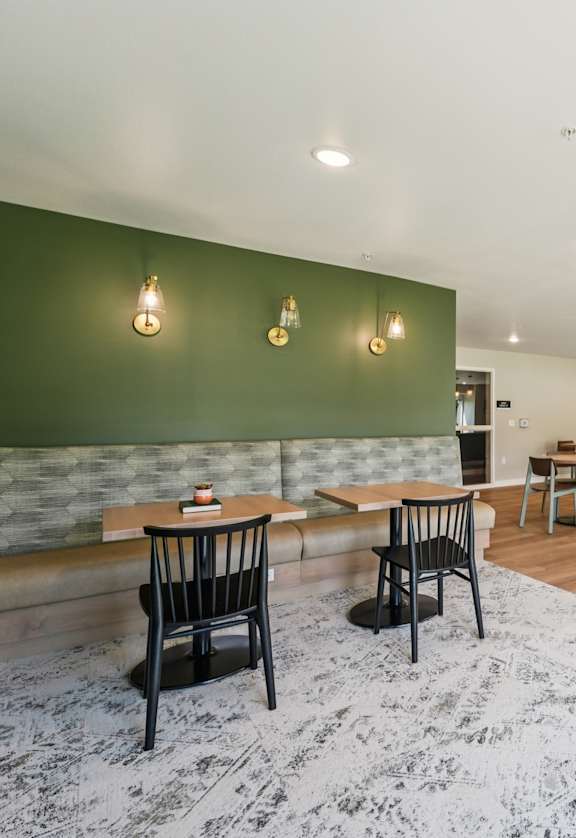 A room with a green wall and a grey carpet.