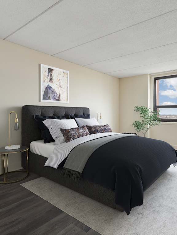 A bedroom with a large bed and a window overlooking the ocean.