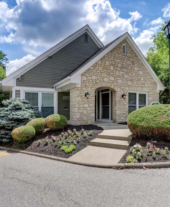 A house with a grey roof and stone pillars.
