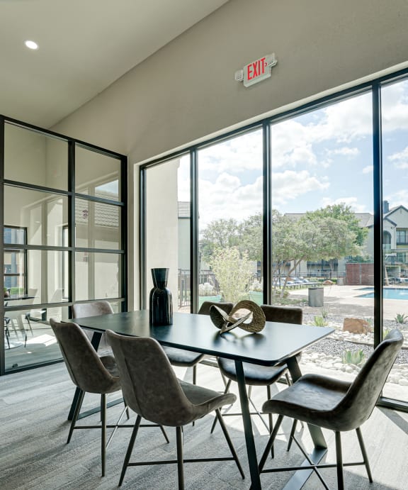 Dining room with a table and chairs in front of a large window  at Carmel Creekside, Texas