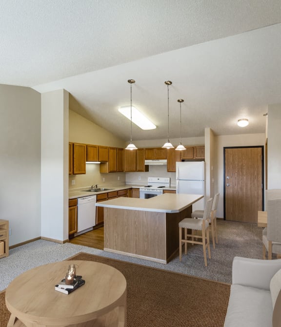Bismarck, ND Sunset Ridge |a living room and kitchen with a couch and a table Bismarck, ND Sunset Ridge |a living room and kitchen with a couch and a table
