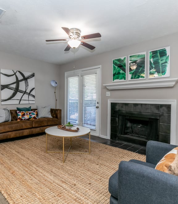 a living room with a ceiling fan and a fireplace at The Atlantic Newtown, Alpharetta, 30022