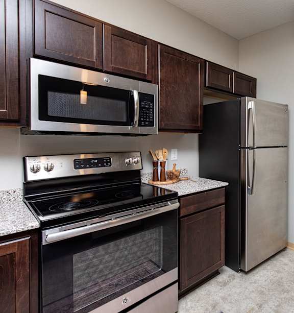 A kitchen with a stove, oven, microwave, and refrigerator. at Lake Shore Apartments, Ankeny, Iowa