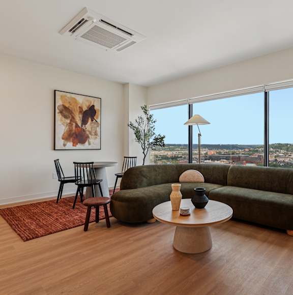 A living room with a green couch and a painting on the wall at 7 West 7th Apartments, Cincinnati, OH