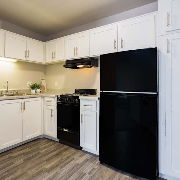 a kitchen with black appliances and white cabinets