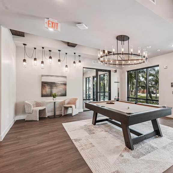 A room with a pool table and a chandelier at The Stadler Luxury Apartments, Florida