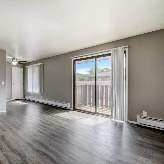 an empty living room with sliding glass doors to a balcony