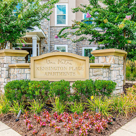 A bedroom with a bed, bench, and window. at Kensington Place Apartments, Woodbridge, 22191