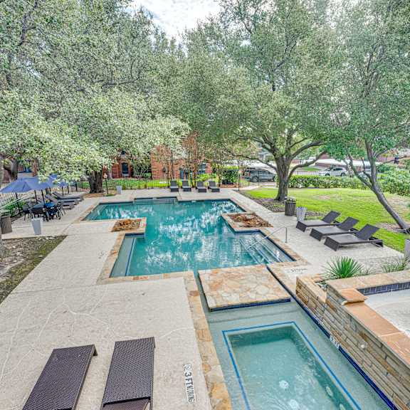 a backyard with a swimming pool and trees at Indian Creek Apartments, Carrollton
