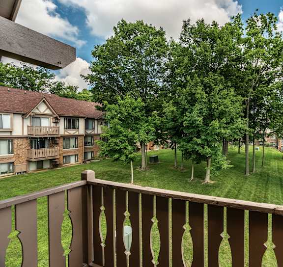  A balcony overlooks a grassy area with trees at Autumn Woods Apartments, Miamisburg, OH, 45342