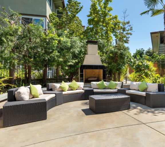 a seating area with couches and pillows in front of a fire pit at Orange Grove Circle, Pasadena, CA,91105