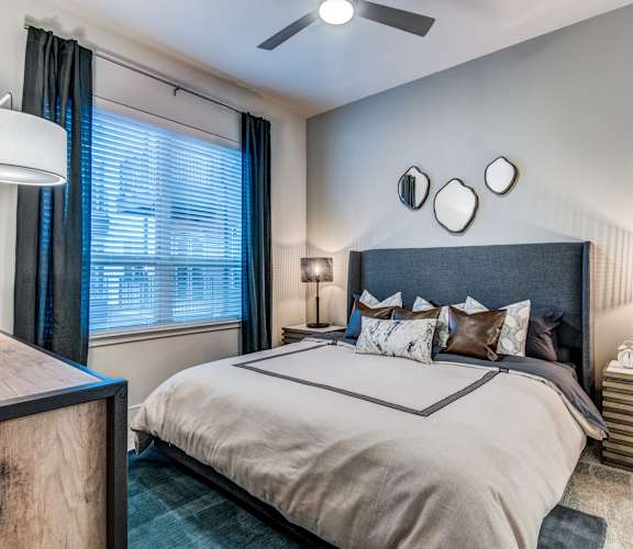 A bedroom with a large bed and a ceiling fan.