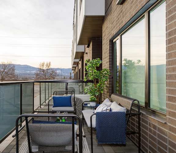 A balcony with a table and chairs overlooking a mountain range.