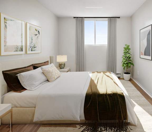 A bedroom with a large bed and a potted plant.