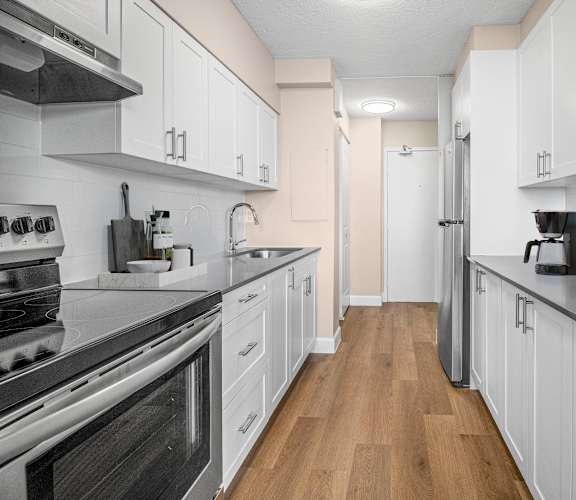 A kitchen with white cabinets and stainless steel appliances.