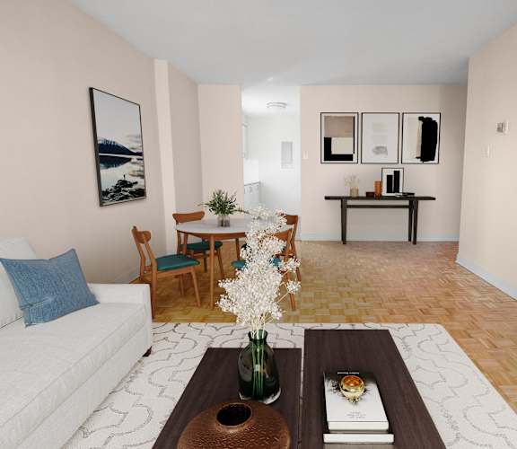 A living room with a white couch, a coffee table with a vase of flowers, and a dining table with chairs.
