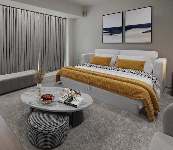 A modern bedroom with a large bed and a grey sofa.