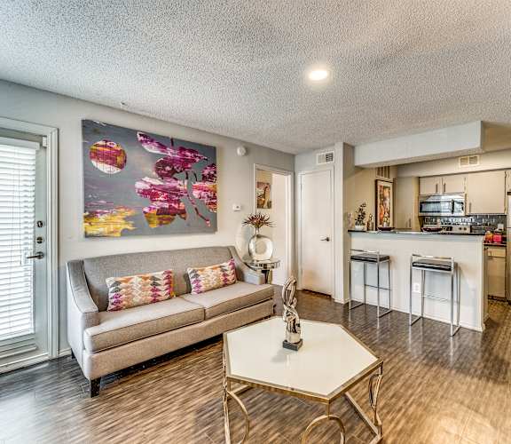 a living room with a couch and a table and a kitchen