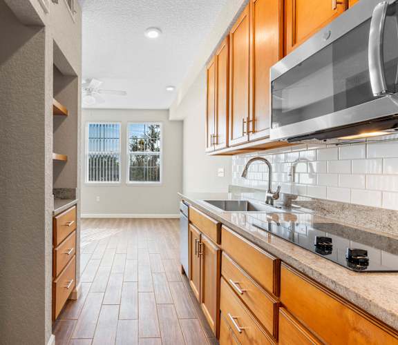 a kitchen with wooden cabinets and a large window