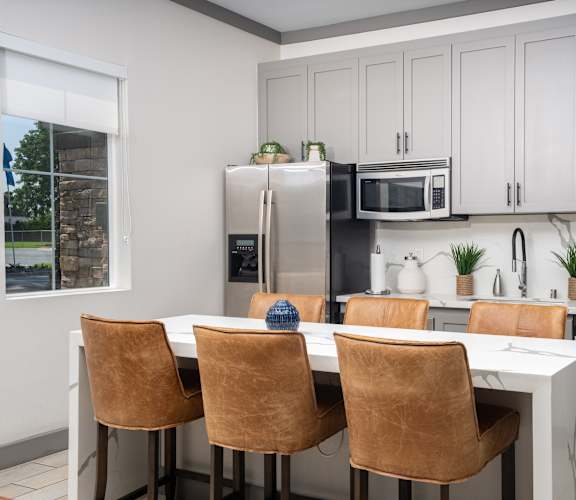 A kitchen with a table and chairs in front of a refrigerator.