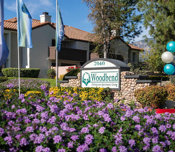 A sign for Woodbend Demonstration Farm is in front of a building.
