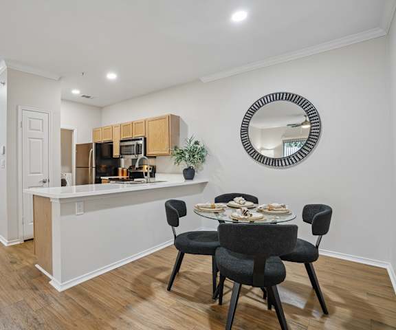 A kitchen with a dining table and chairs.