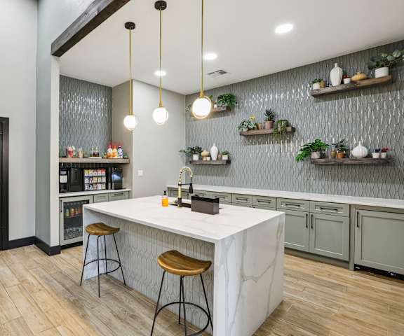 a kitchen with a marble counter top and two stools at Ventana Oaks Apartments, Austin, TX