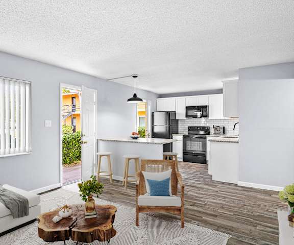 A modern kitchen with white cabinets and a wooden floor.