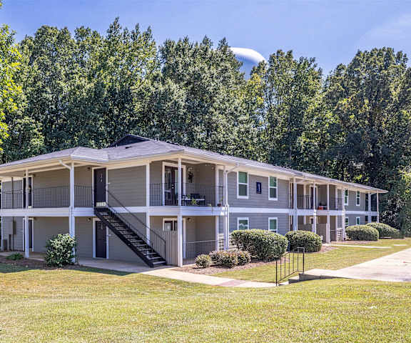 A large apartment complex with a green lawn in front.
