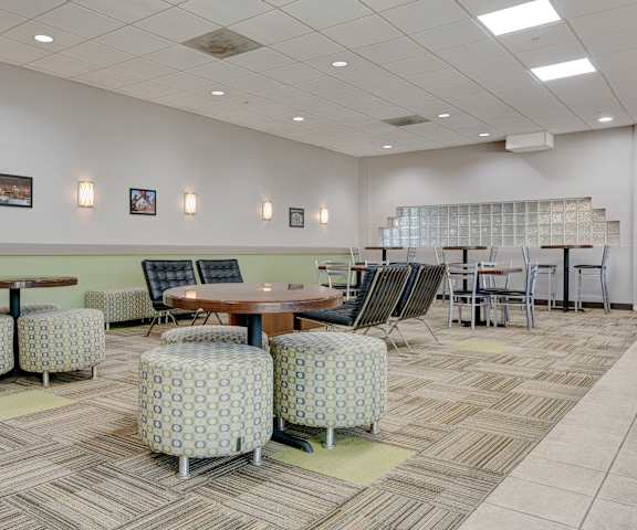 a seating area with tables and chairs in a lobby