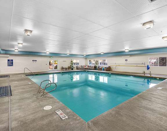 a large indoor swimming pool with a diving board at Camelot Apartment Homes in Everett, WA