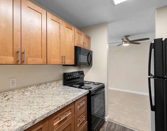 a kitchen with granite countertops and black appliances at Park Edmonds Apartment Homes, Edmonds, WA