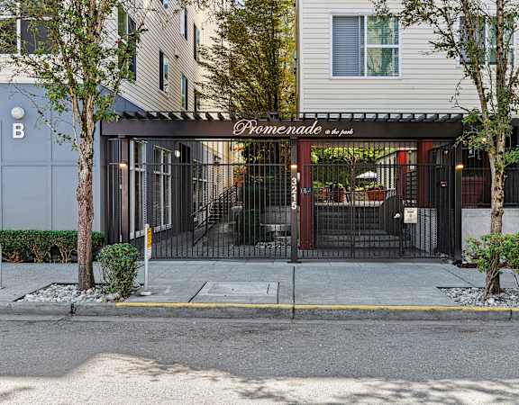 the entrance to a building with a black gate and white lettering on the front of it at Promenade at the Park Apartment Homes in Seattle, WA