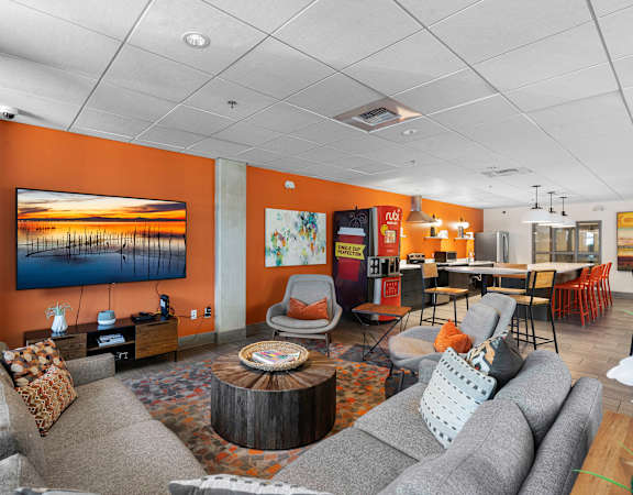 a living room with couches and chairs and a television at Sedona Apartments in Seattle, WA